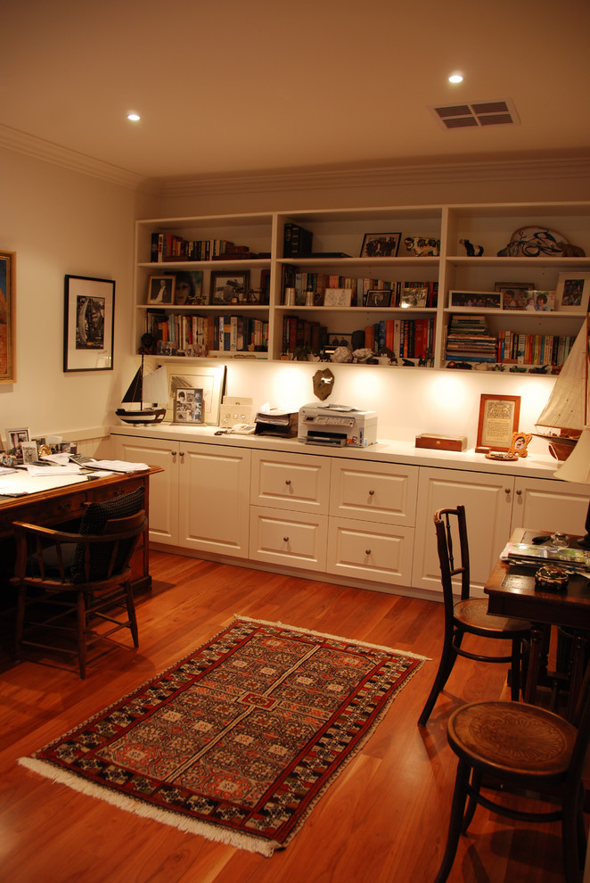 This is an example of a mid-sized country study room in Geelong with beige walls, medium hardwood floors, a freestanding desk and no fireplace.