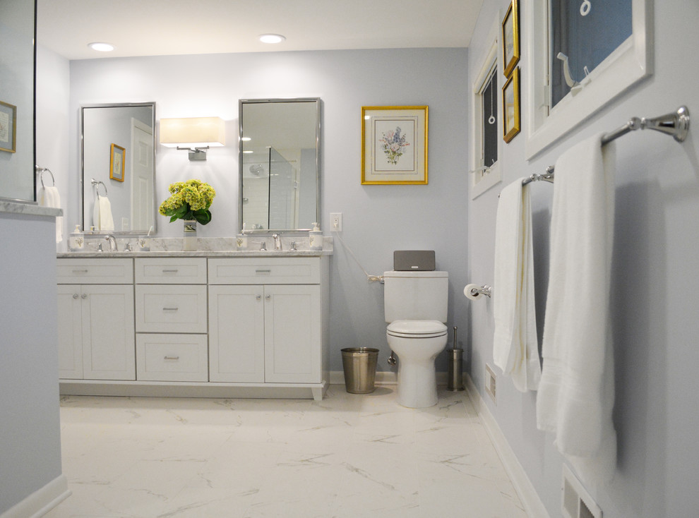 Design ideas for a large transitional master bathroom in Philadelphia with an undermount sink, flat-panel cabinets, white cabinets, marble benchtops, a drop-in tub, a corner shower, a one-piece toilet, white tile, stone tile, grey walls and marble floors.