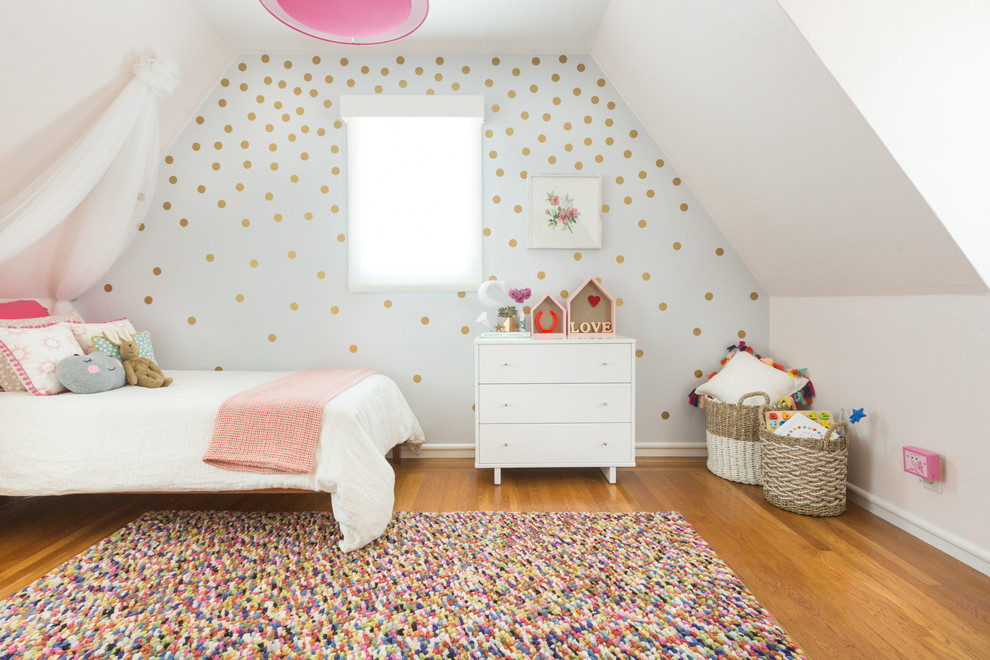 This is an example of a mid-sized scandinavian kids' bedroom for kids 4-10 years old and girls in San Francisco with white walls and medium hardwood floors.