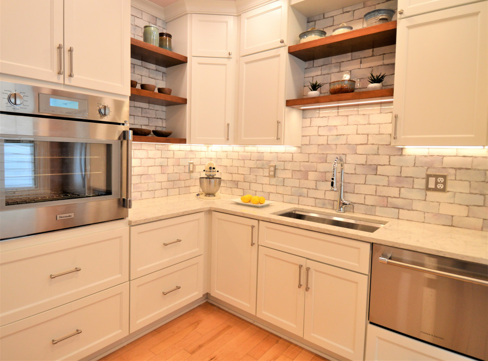 Kitchen - small transitional light wood floor kitchen idea in Milwaukee with a single-bowl sink, shaker cabinets, white cabinets, quartzite countertops, ceramic backsplash and stainless steel appliances