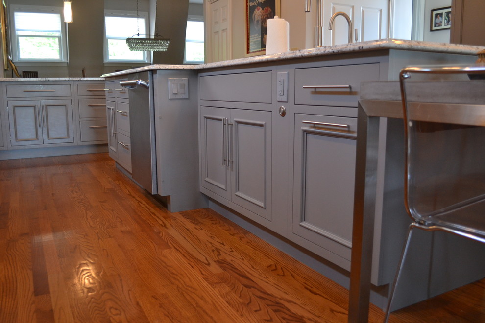 Large transitional l-shaped medium tone wood floor open concept kitchen photo in Cincinnati with an undermount sink, gray cabinets, granite countertops, multicolored backsplash, mosaic tile backsplash, stainless steel appliances, an island and beaded inset cabinets