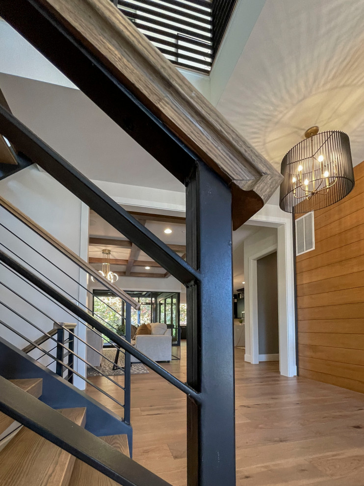 Foto de escalera recta actual grande con escalones de madera, barandilla de varios materiales y panelado