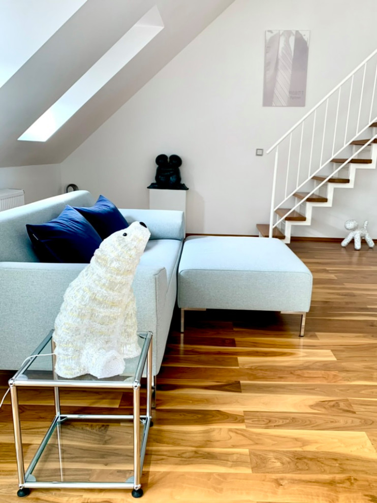 Modernes Wohnzimmer mit weißer Wandfarbe, braunem Holzboden und braunem Boden in München