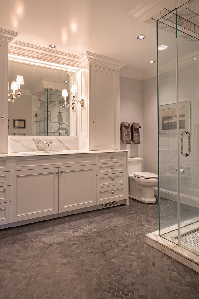 Design ideas for a mid-sized traditional master bathroom in Omaha with an undermount sink, recessed-panel cabinets, white cabinets, marble benchtops, a corner shower, a two-piece toilet, gray tile, stone tile, grey walls and slate floors.