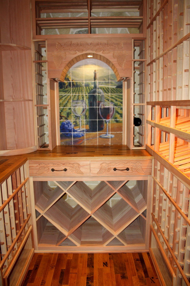 Design ideas for a small traditional wine cellar in Dallas with medium hardwood floors and diamond bins.