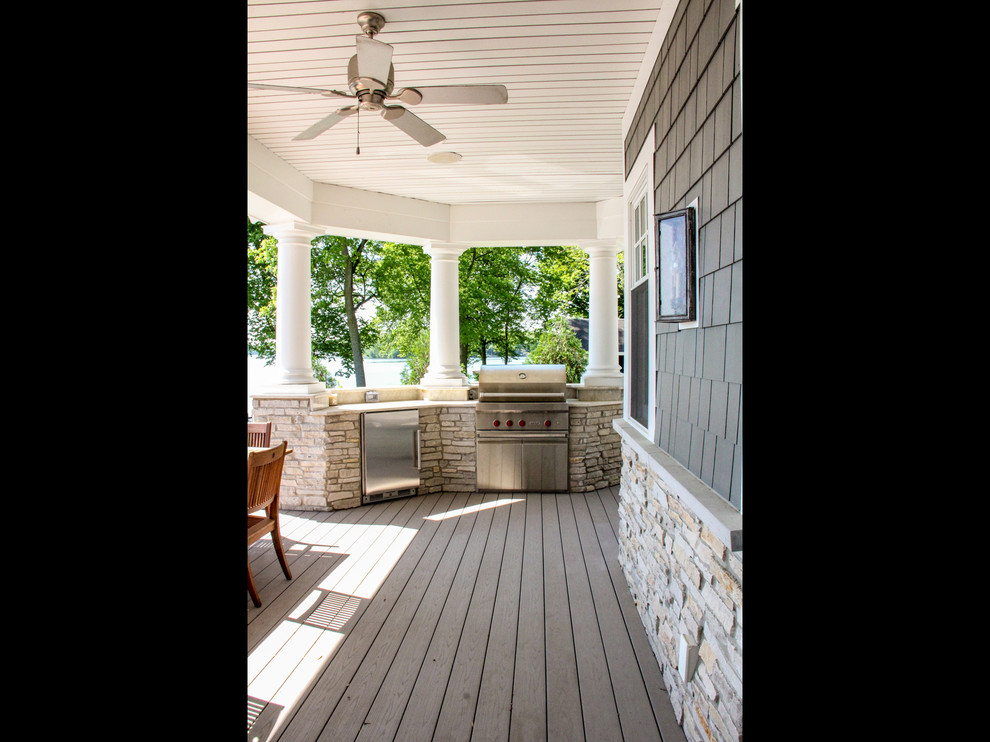 This is an example of a large beach style backyard deck in Other with an outdoor kitchen and a roof extension.