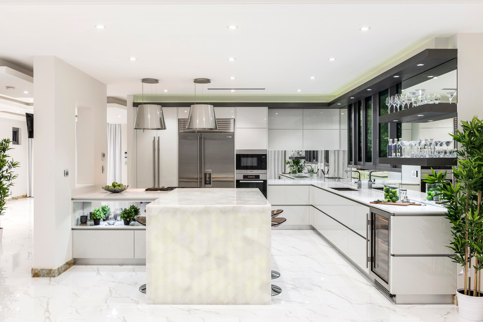 Contemporary l-shaped eat-in kitchen in Brisbane with an undermount sink, flat-panel cabinets, white cabinets, quartz benchtops, metallic splashback, mirror splashback, stainless steel appliances, marble floors and with island.