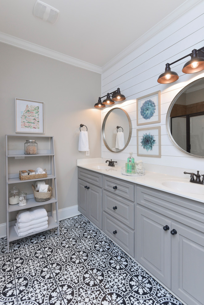 Large country bathroom in Other with raised-panel cabinets, grey cabinets, black and white tile, ceramic tile, grey walls, ceramic floors, solid surface benchtops, black floor, white benchtops, an enclosed toilet, a double vanity, a built-in vanity and planked wall panelling.