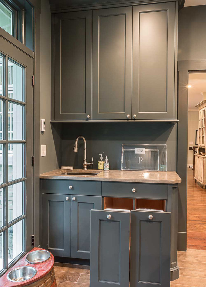 Photo of a large scandinavian utility room in Chicago with an undermount sink, flat-panel cabinets, grey cabinets, quartz benchtops, grey walls, medium hardwood floors and a side-by-side washer and dryer.