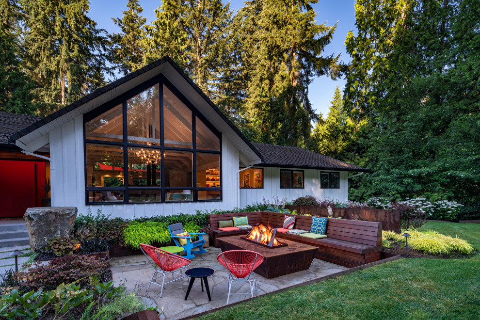 Example of a small mid-century modern front yard stone patio design in Seattle with a fire pit and no cover