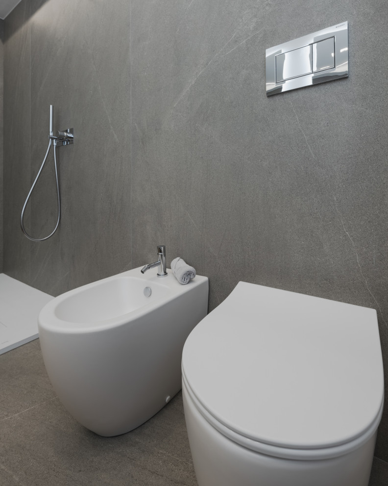 Inredning av ett modernt mellanstort vit vitt badrum med dusch, med släta luckor, vita skåp, en öppen dusch, en toalettstol med separat cisternkåpa, grå kakel, porslinskakel, vita väggar, ljust trägolv, ett nedsänkt handfat, bänkskiva i akrylsten och beiget golv