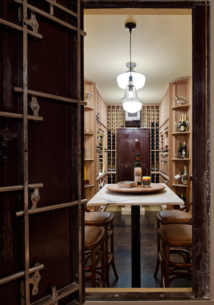 Transitional wine cellar in Seattle with concrete floors and storage racks.