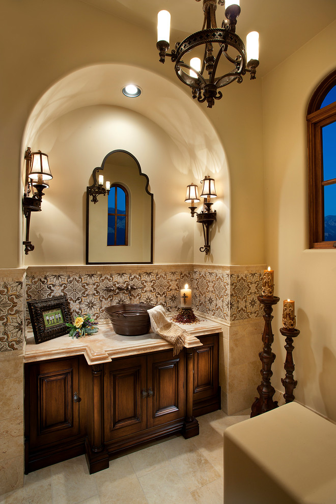 Expansive traditional master bathroom in Phoenix with furniture-like cabinets, brown cabinets, a freestanding tub, an alcove shower, a one-piece toilet, multi-coloured tile, porcelain tile, multi-coloured walls, marble floors, a vessel sink, marble benchtops, beige floor, a hinged shower door and multi-coloured benchtops.