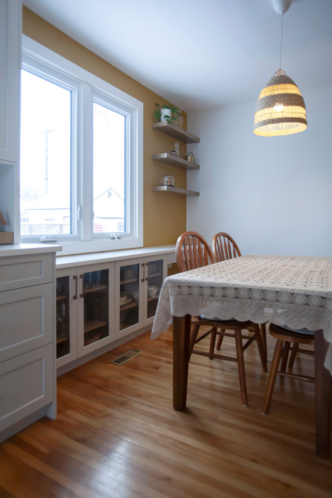 Mid-sized transitional single-wall eat-in kitchen photo with an undermount sink, shaker cabinets, white cabinets, quartz countertops, porcelain backsplash, stainless steel appliances, no island and white countertops
