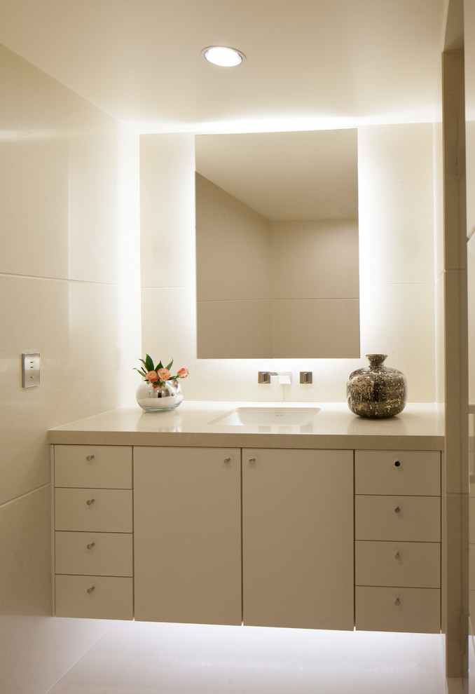 Photo of a small modern 3/4 bathroom in Seattle with white tile, beige walls, white floor, flat-panel cabinets, white cabinets, an undermount sink, engineered quartz benchtops and white benchtops.