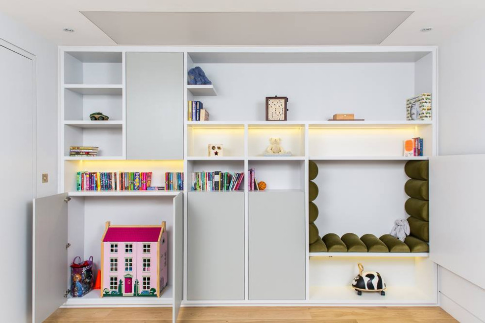 Inspiration for a mid-sized contemporary gender-neutral kids' playroom for kids 4-10 years old in London with white walls and beige floor.