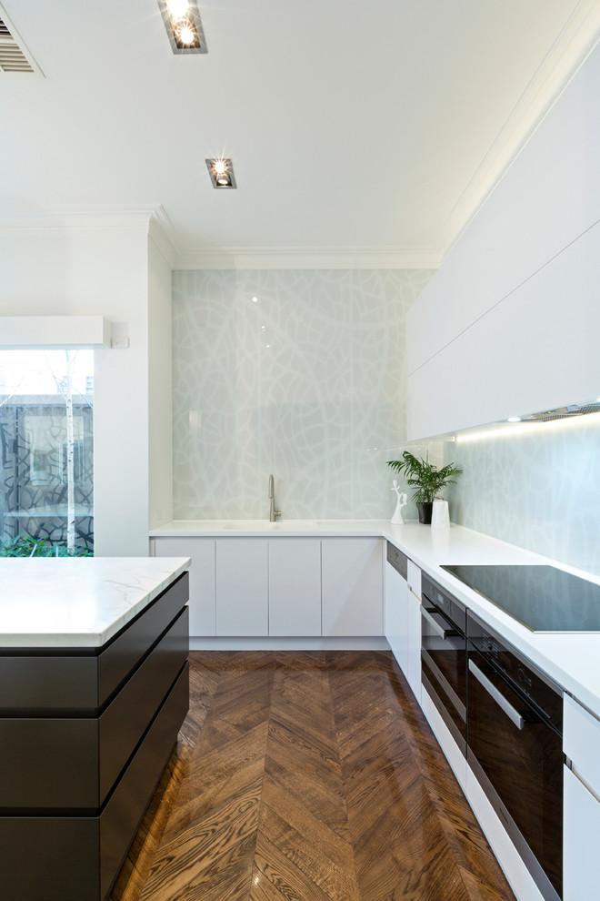 Contemporary l-shaped eat-in kitchen in Melbourne with an integrated sink, flat-panel cabinets, white cabinets, marble benchtops, grey splashback, glass sheet splashback and with island.