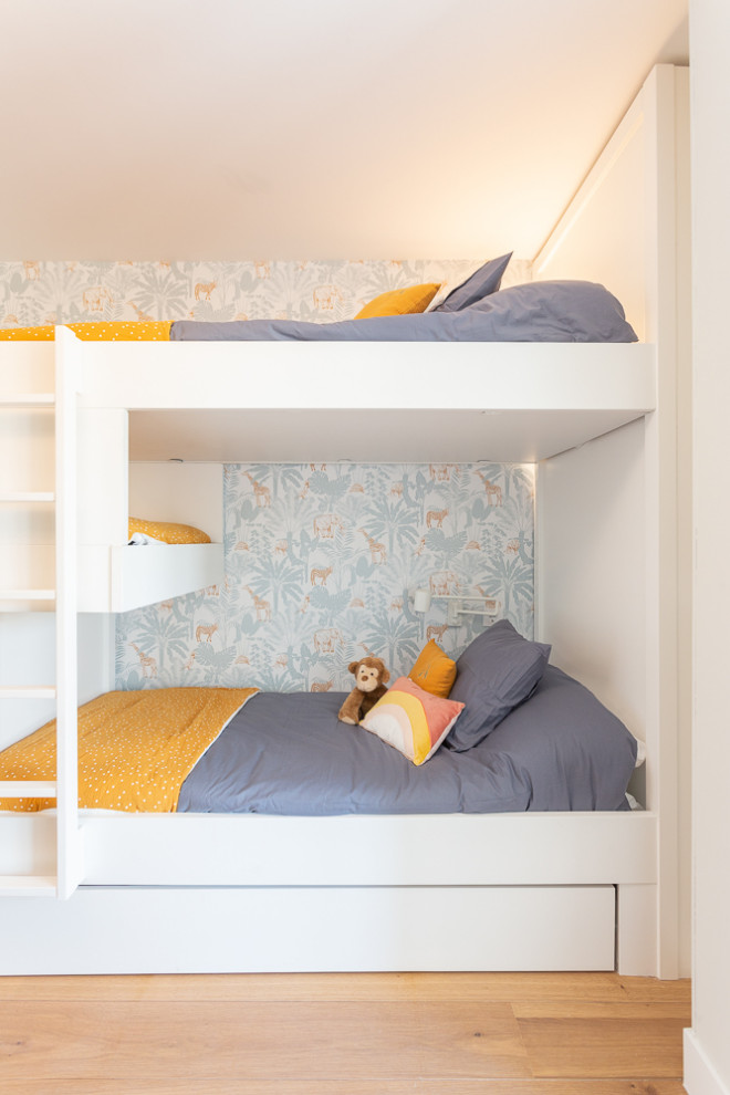 Photo of a large transitional gender-neutral kids' bedroom for kids 4-10 years old in Madrid with blue walls and ceramic floors.