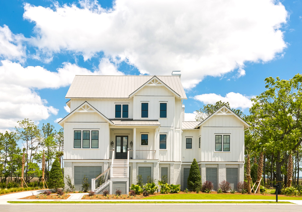 Example of a large beach style white two-story concrete fiberboard house exterior design in Charleston with a metal roof