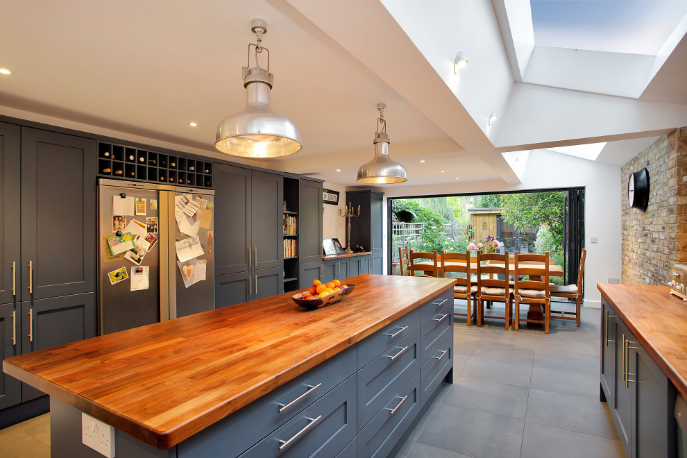 Inspiration for a transitional galley eat-in kitchen in London with shaker cabinets, grey cabinets, wood benchtops, with island, grey floor and brown benchtop.