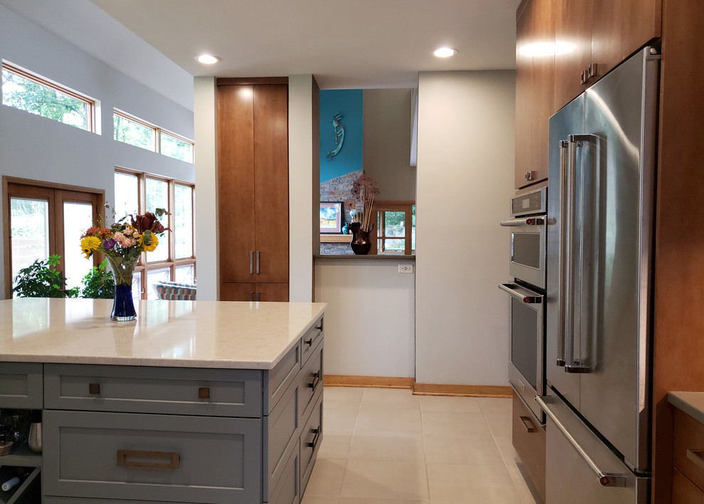 Mid-sized modern u-shaped eat-in kitchen in Other with an undermount sink, flat-panel cabinets, medium wood cabinets, quartz benchtops, multi-coloured splashback, slate splashback, stainless steel appliances, concrete floors, with island, grey floor and grey benchtop.