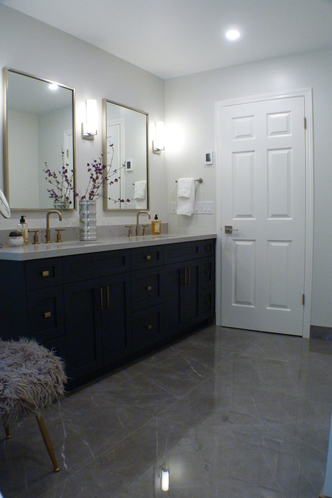Modern inredning av ett stort grå grått en-suite badrum, med skåp i shakerstil, blå skåp, ett fristående badkar, en kantlös dusch, en toalettstol med hel cisternkåpa, vita väggar, klinkergolv i keramik, ett undermonterad handfat, bänkskiva i kvarts, grått golv och med dusch som är öppen