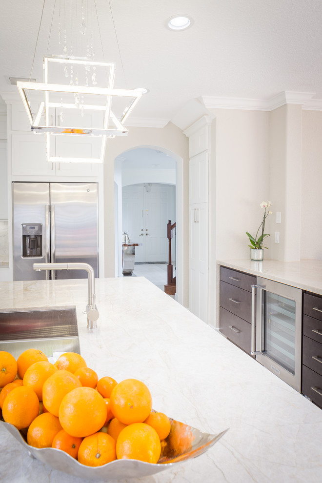 Inspiration for a large transitional l-shaped porcelain tile open concept kitchen remodel in Miami with an undermount sink, shaker cabinets, white cabinets, subway tile backsplash, stainless steel appliances and two islands