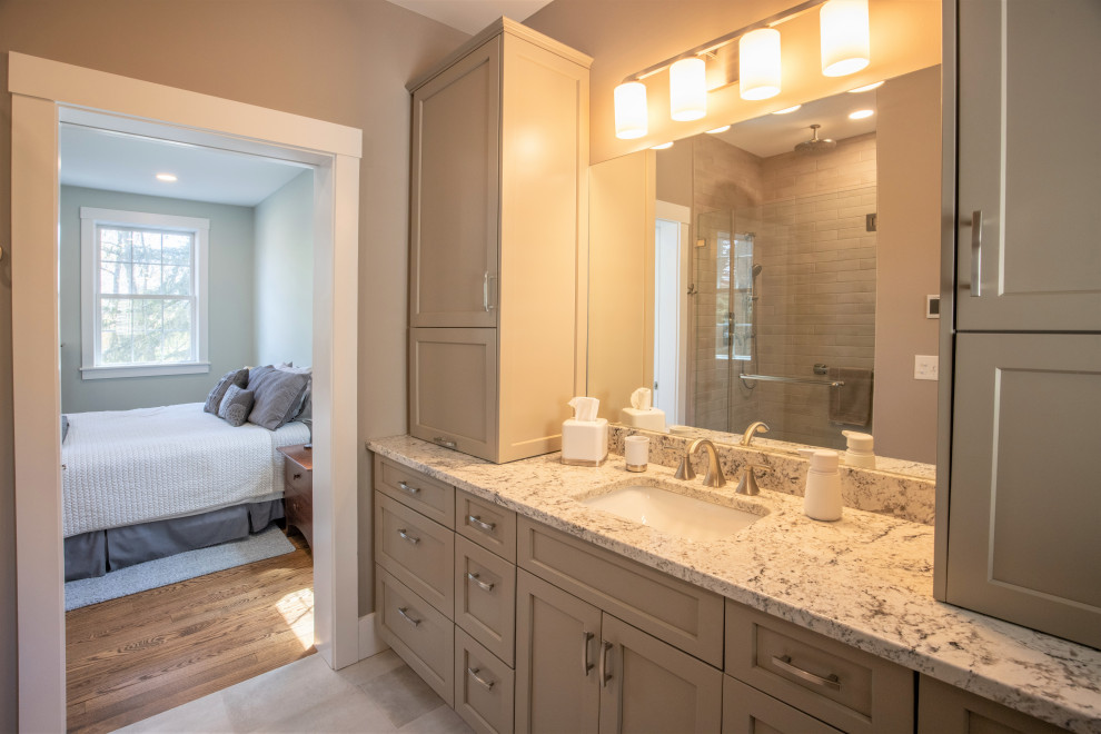 Design ideas for a large traditional ensuite bathroom in Boston with shaker cabinets, beige cabinets, an alcove shower, beige tiles, ceramic tiles, beige walls, porcelain flooring, a submerged sink, granite worktops, beige floors, a hinged door, white worktops, a single sink and a built in vanity unit.