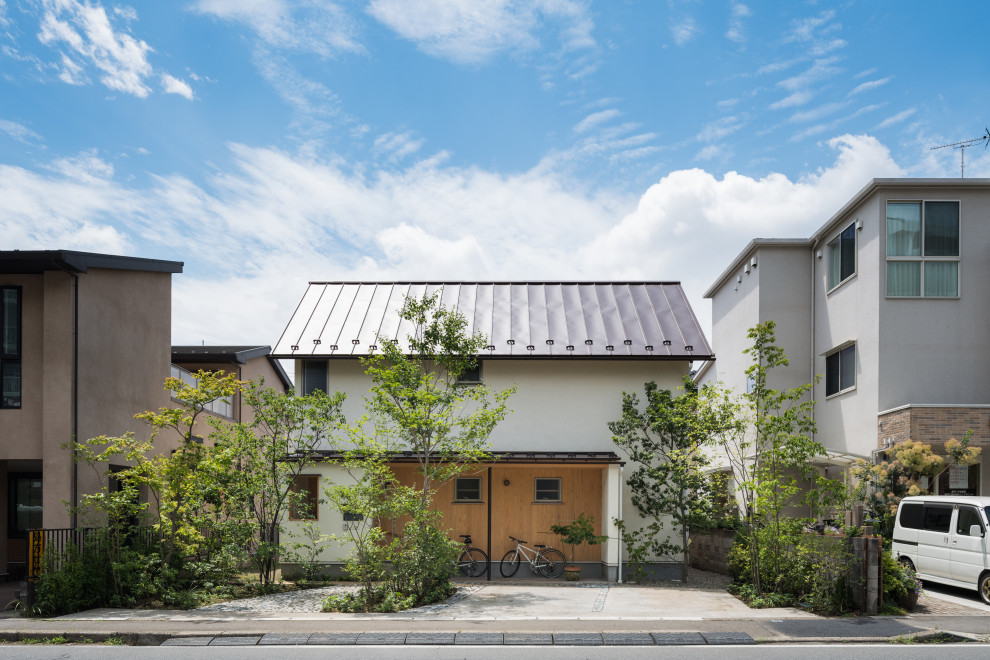 Стильный дизайн: двухэтажный, белый частный загородный дом с облицовкой из цементной штукатурки, двускатной крышей, металлической крышей и коричневой крышей - последний тренд