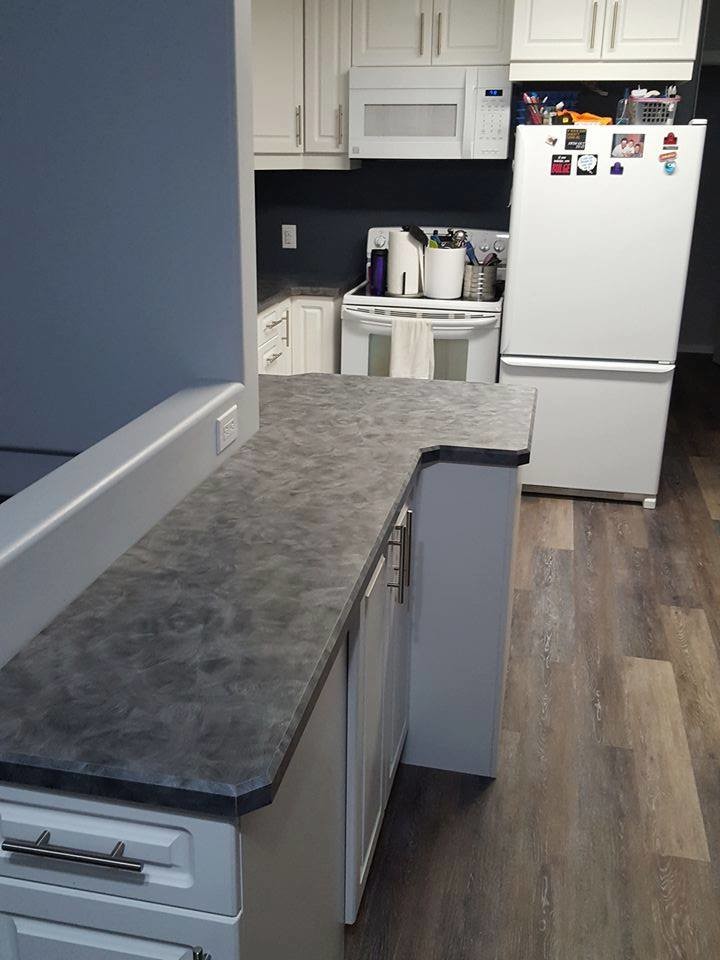 Inspiration for a transitional medium tone wood floor and brown floor kitchen remodel with raised-panel cabinets, white cabinets, white appliances, a double-bowl sink and laminate countertops