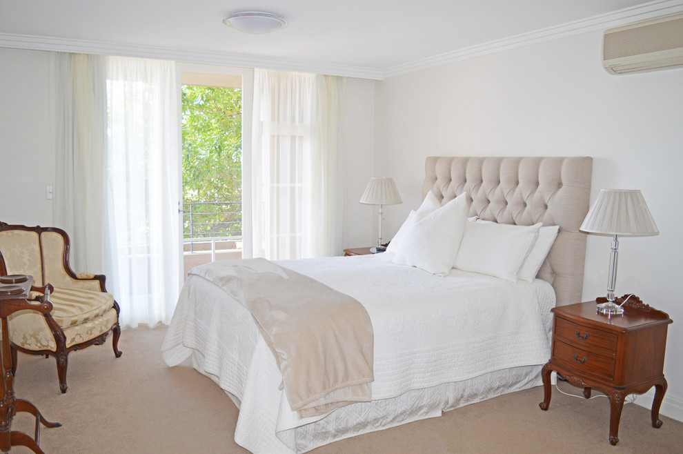 Large transitional master bedroom in Sydney with white walls, carpet and beige floor.
