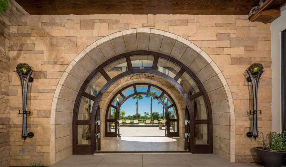 This is an example of a mediterranean front door in San Diego with a double front door and a glass front door.