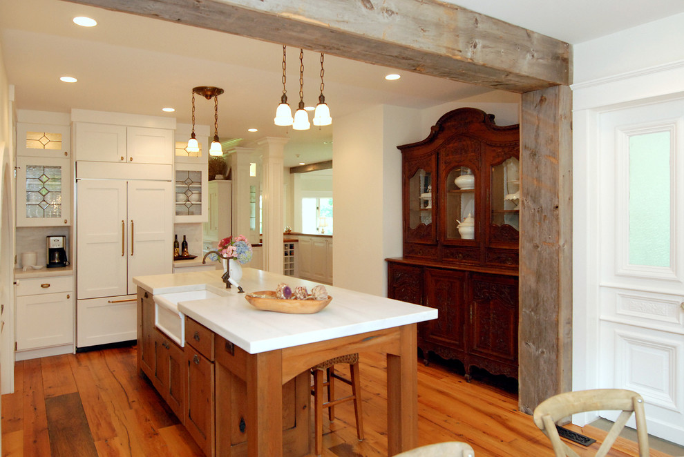 Inspiration for a mid-sized country l-shaped eat-in kitchen in New York with recessed-panel cabinets, white cabinets, grey splashback, stainless steel appliances, medium hardwood floors, with island, a farmhouse sink, marble benchtops and stone tile splashback.