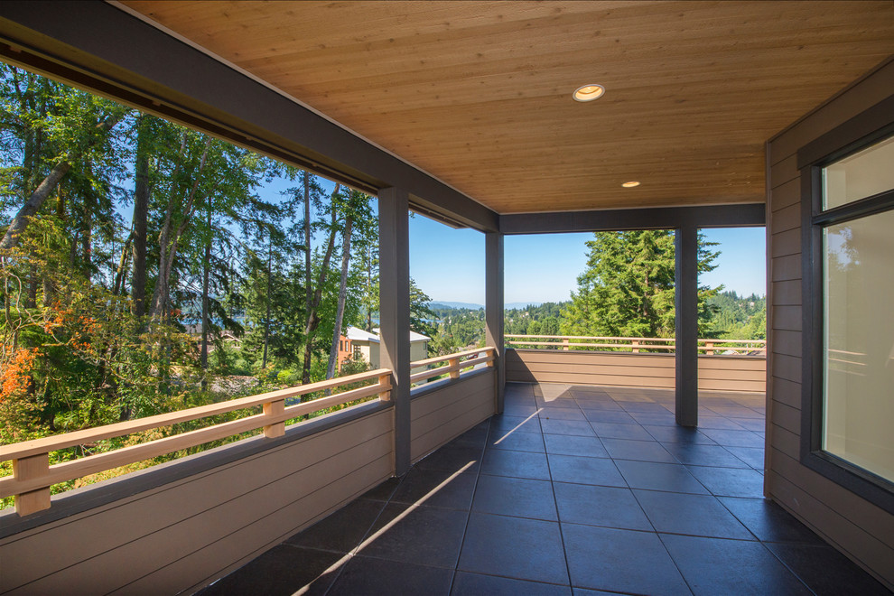 Large transitional side yard balcony deck photo in Seattle with a roof extension