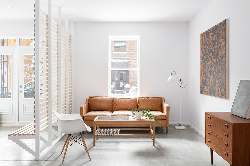 Example of a danish enclosed concrete floor and gray floor living room design in Montreal with white walls and no fireplace