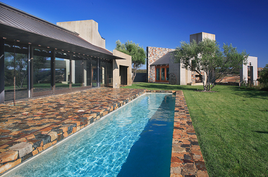 Photo of a large backyard full sun garden in Orange County with a water feature and natural stone pavers.