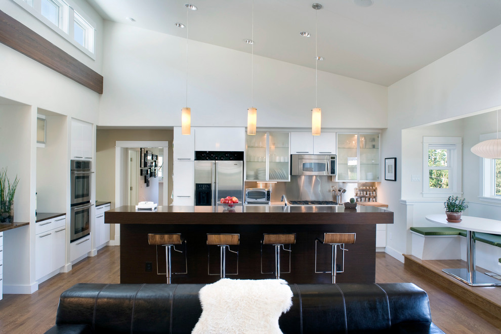 This is an example of a contemporary eat-in kitchen in Boise with glass-front cabinets, white cabinets and stainless steel appliances.