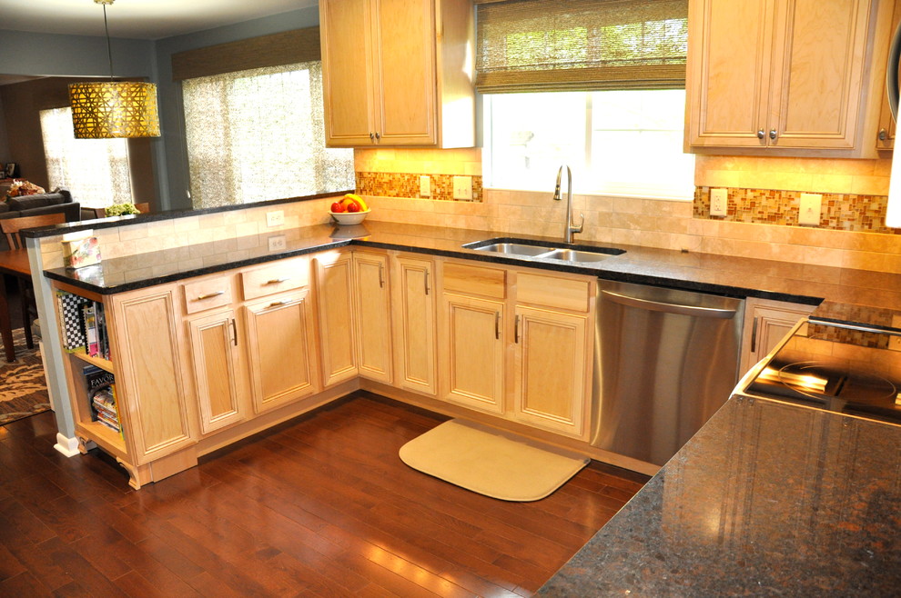 Inspiration for a mid-sized transitional u-shaped dark wood floor enclosed kitchen remodel in Cincinnati with an undermount sink, shaker cabinets, light wood cabinets, granite countertops, beige backsplash, stainless steel appliances and blue walls