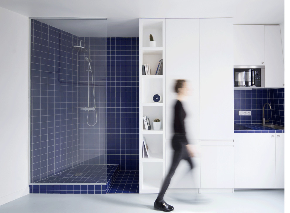 Small contemporary master bathroom in Paris with beaded inset cabinets, white cabinets, a curbless shower, white tile, blue tile, matchstick tile, blue walls, concrete floors, grey floor and an open shower.