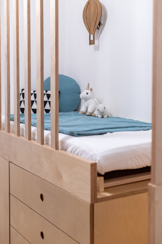 Cette photo montre une petite chambre d'enfant de 4 à 10 ans tendance avec un mur blanc et parquet clair.