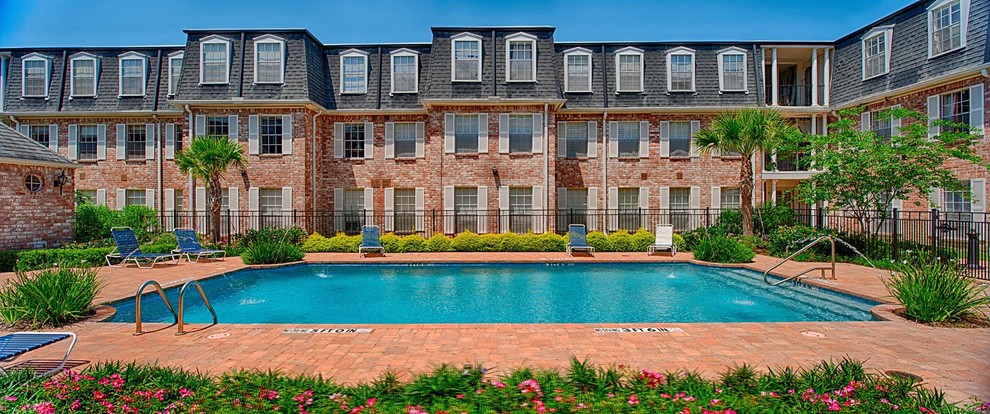 Inspiration for a large traditional courtyard rectangular lap pool in Houston with brick pavers.
