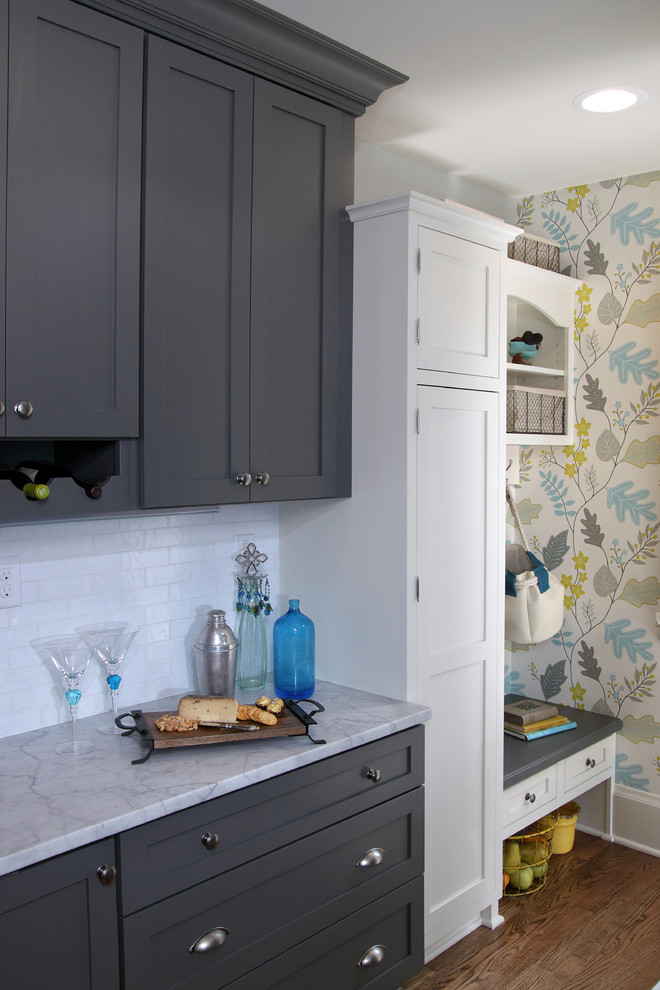 Inspiration for a mid-sized transitional u-shaped dark wood floor and brown floor eat-in kitchen remodel in Milwaukee with a farmhouse sink, shaker cabinets, gray cabinets, white backsplash, subway tile backsplash, stainless steel appliances, gray walls, quartzite countertops, a peninsula and white countertops