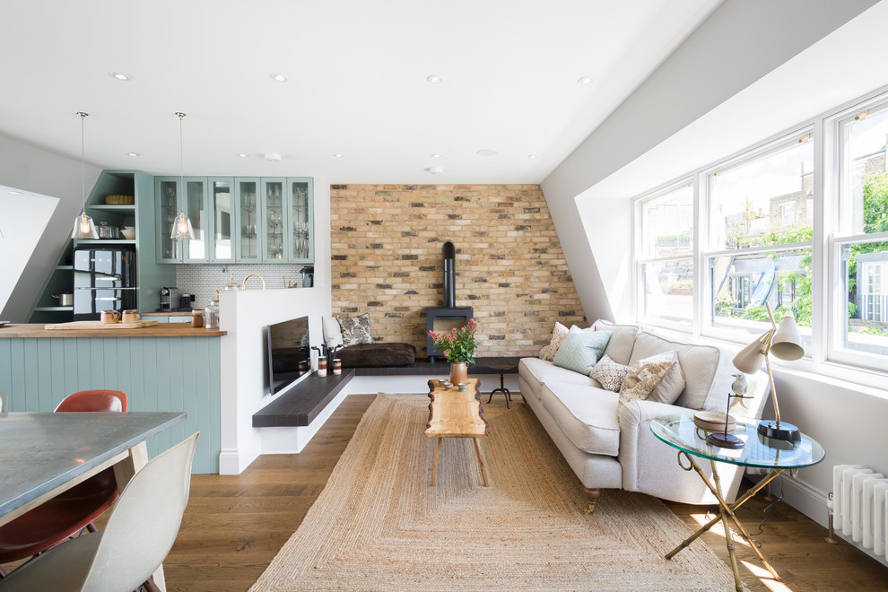 Photo of a farmhouse formal open plan living room feature wall in London with white walls, medium hardwood flooring, a wood burning stove, a wall mounted tv, a feature wall and feature lighting.