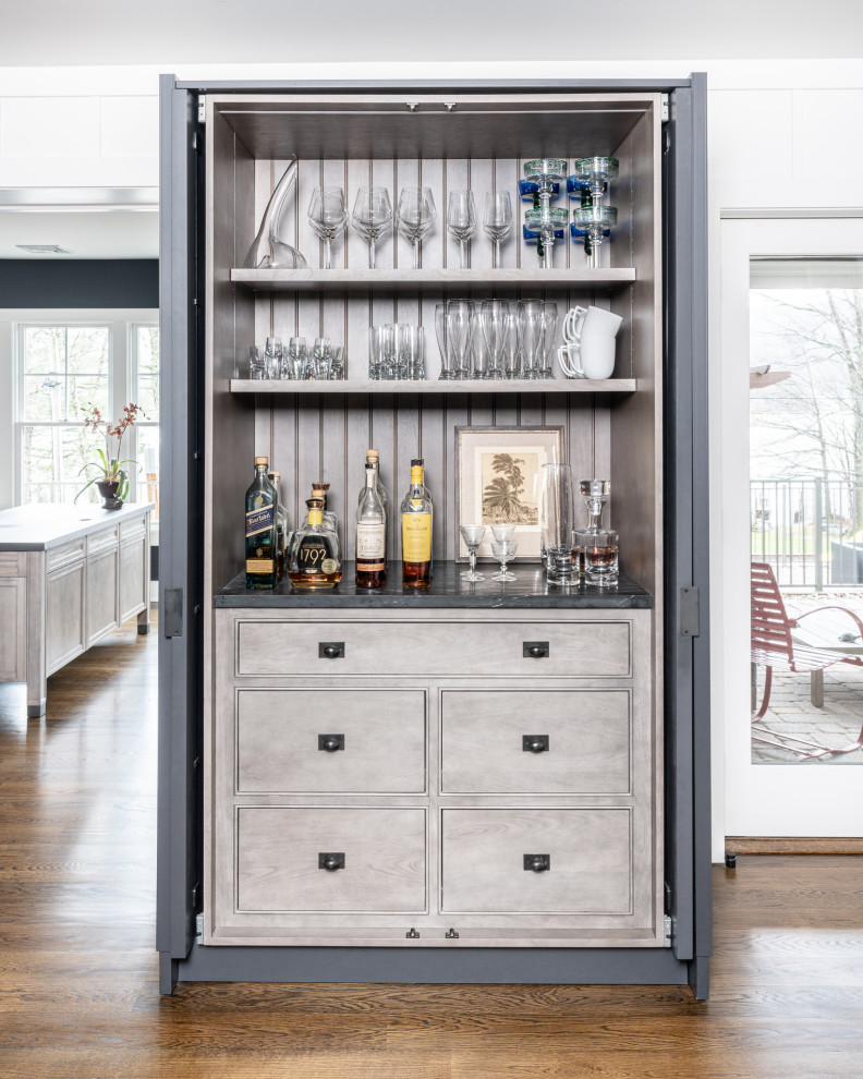 Inspiration for a small transitional galley home bar in New York with an undermount sink, flat-panel cabinets, grey cabinets, marble benchtops, white splashback, marble splashback, dark hardwood floors, brown floor and white benchtop.