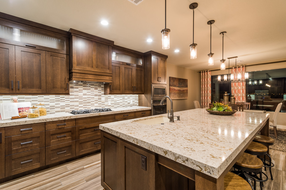 Large country l-shaped eat-in kitchen in Salt Lake City with an undermount sink, shaker cabinets, dark wood cabinets, granite benchtops, grey splashback, matchstick tile splashback, stainless steel appliances, porcelain floors and with island.