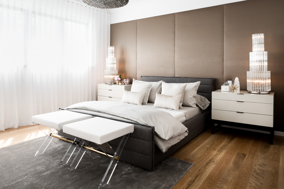 This is an example of a mid-sized contemporary master bedroom in Melbourne with white walls, medium hardwood floors, no fireplace and brown floor.