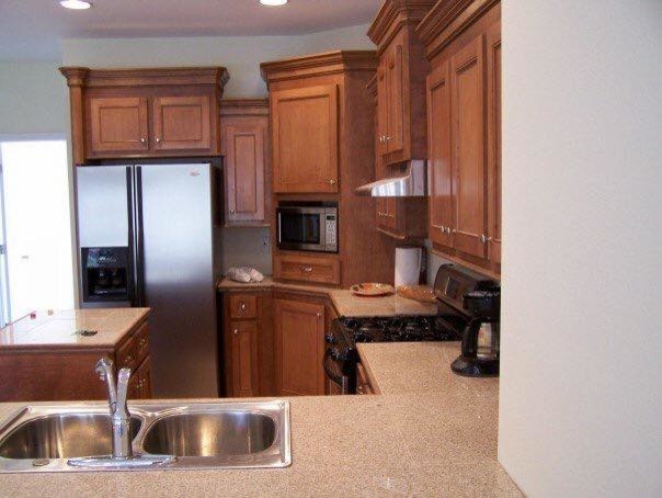 Inspiration for a mid-sized transitional kitchen remodel in Jackson with a drop-in sink, medium tone wood cabinets, granite countertops, stainless steel appliances and an island