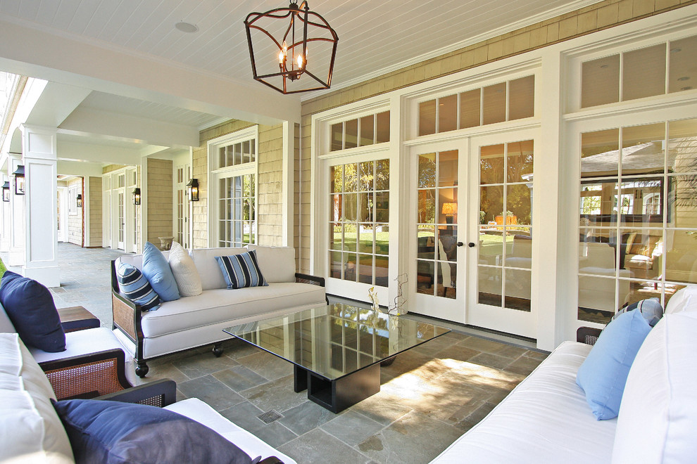 This is an example of a large traditional backyard verandah in Los Angeles with natural stone pavers.