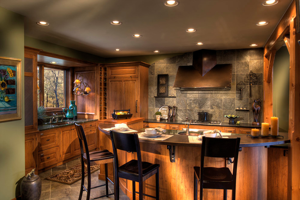 Mountain style slate floor kitchen photo with an undermount sink, light wood cabinets, paneled appliances, stone tile backsplash and an island