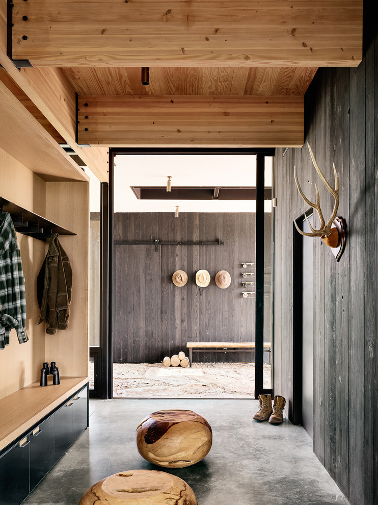 This is an example of a contemporary mudroom in Austin with concrete floors, a sliding front door and grey floor.